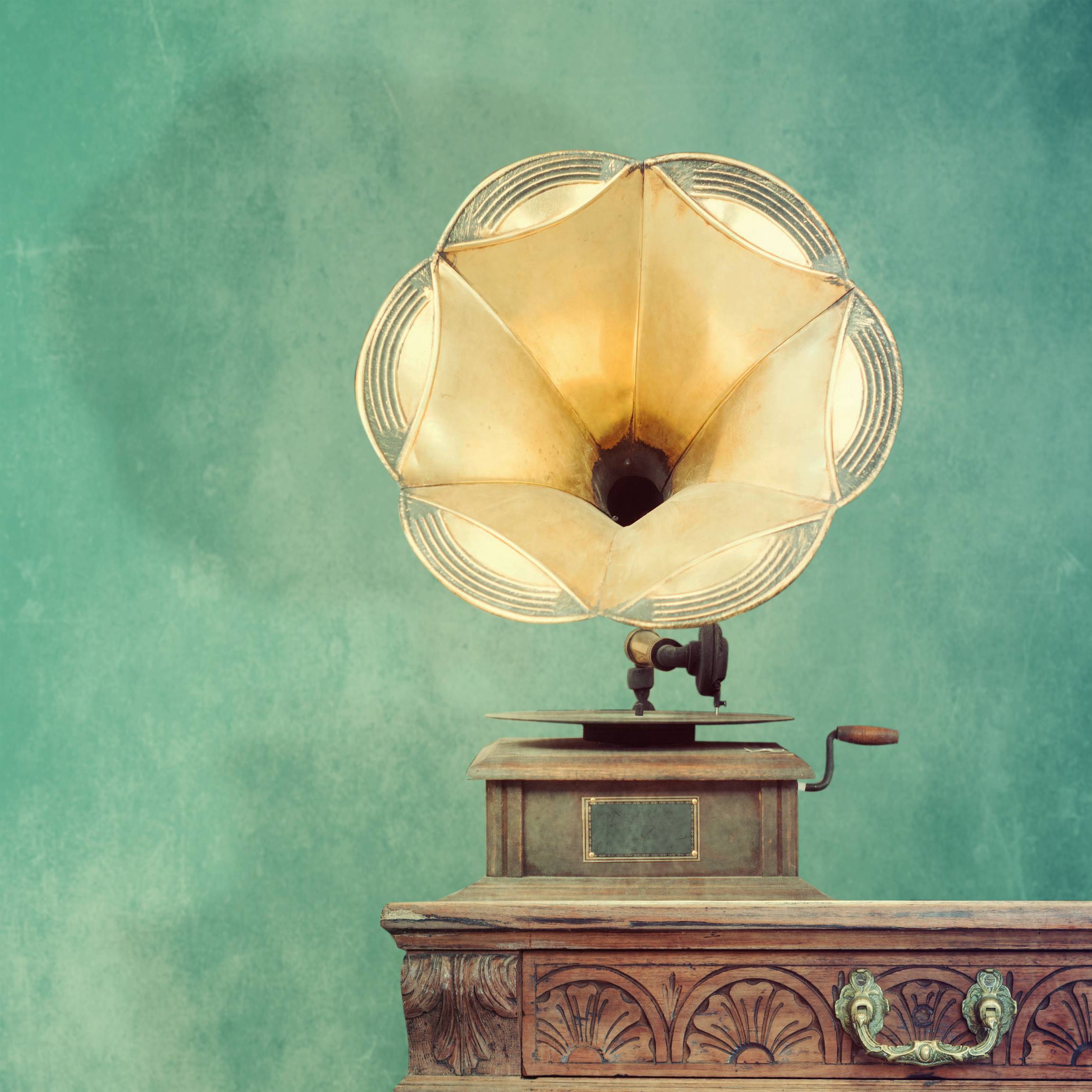 an old fashion record player on a table with a beautiful green background